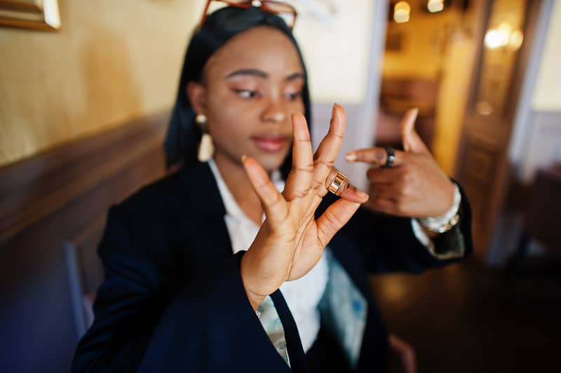 Young deaf mute african american woman using sign language.